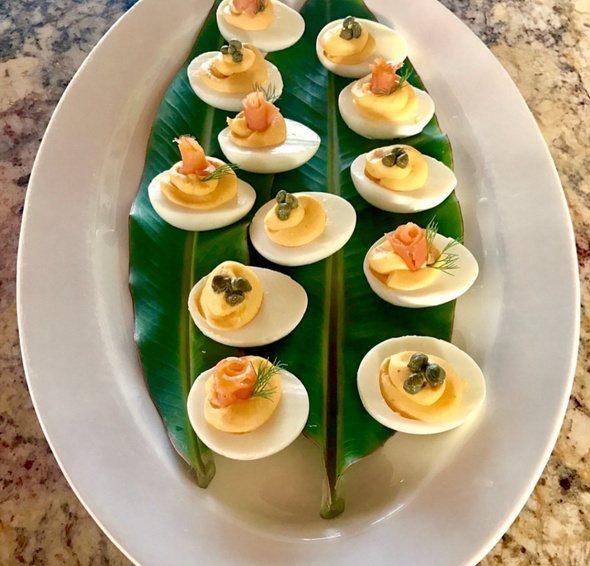 Deviled eggs with smoked salmon on a banana leaf